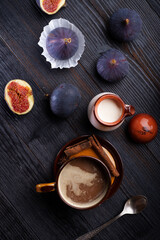 Obraz na płótnie Canvas coffee with natural cream and tasty ripe purple fig on black wooden table. flat lay
