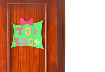 Wooden door with a sign made of eva rubber that says toy room and white background