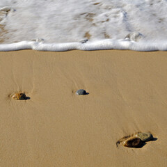Ocean tide and sand patterns with rocks
