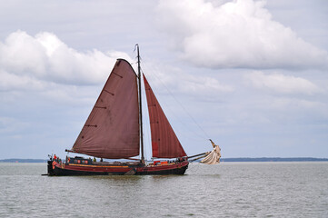Plattboden-Schiff mit roten Segeln auf dem Ijsselmeer