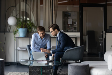 Serious leader boss in formal suit discussing business project online computer presentation or...