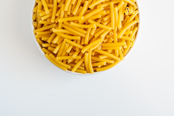 Raw dry uncooked Macaroni pasta spaghetti noodle on white bowl wooden background for basil tomato pesto sauce Homemade Italian food organic whole wheat vegan spaghetti for a healthy meal