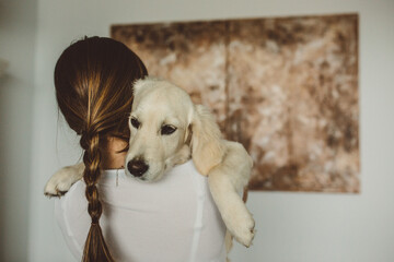 person hugging golden retriever dog