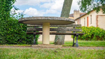 Fototapeta na wymiar Ground view of a round stone table and bench, outdoors 
