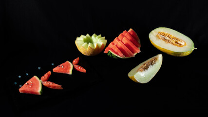 
Sets of beautifully cut watermelons and melons, on black background