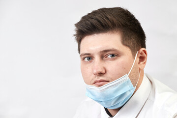 coronavirus concept, man with lowered medical mask on white background