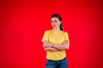 Smiling young woman with crossed arms against red background