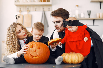 Mother father and children in costumes and makeup. Family prepare to celebration of Halloween.
