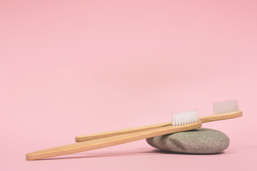 bamboo tooth brushes on a stone pink background place for text