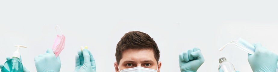 coronavirus concept banner, guy in mask, hands in gloves holds medical elements on white background