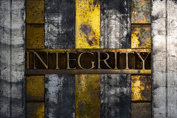 Integrity text formed with real authentic typeset letters on vintage textured silver grunge copper and gold background