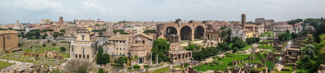 Fototapeta na wymiar Ultra wide view of the ancient Roman Forum and the Colosseum in background in Rome