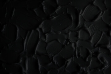 Textured black background. Beautiful black background with a three-dimensional texture. Selective focus.