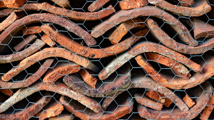 Tiles stacked behind a chicken wire netting, shelter for insects