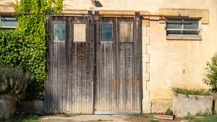 
Large garage door in worn wood, and old structure