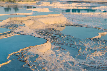 Natural travertine pools and terraces at sunset in Pamukkale, Turkey