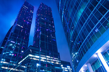 The business center of the city in the evening. Corporate center. Skyscrapers against a dark sky. Tops of glass skyscrapers. Glass walls of office buildings. Commercial real estate. Moscow. Russia.