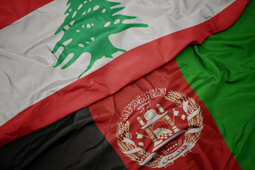 waving colorful flag of afghanistan and national flag of lebanon. macro