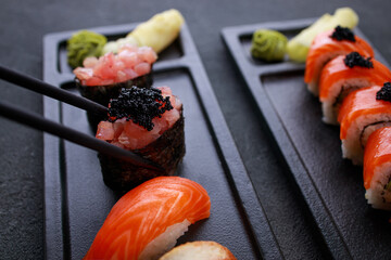 Chopsticks taking gunkan maki sushi from plate © Vadym