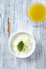 Tzatziki sauce prepared with  cucumber, sour yogurt and fresh basil. Rustic wooden background. Top view. 
