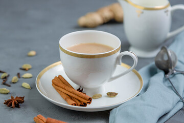 Indian masala tea. Traditional hot drink made from black tea with milk and spices on gray...