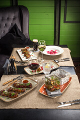 dinner table with ribs, chicken wings, salad and wine served at home or at restaurant
