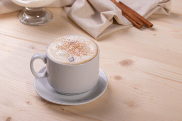 a white ceramic cup of cappucino as a coffee break concept