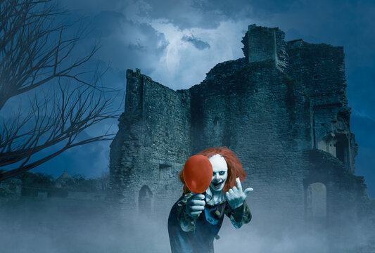 crazy clown with a balloon in a gloomy scene of an old castle