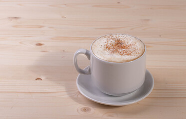 a white ceramic cup of cappucino as a coffee break concept