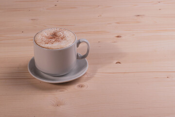 a white ceramic cup of cappucino as a coffee break concept