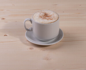 a white ceramic cup of cappucino as a coffee break concept