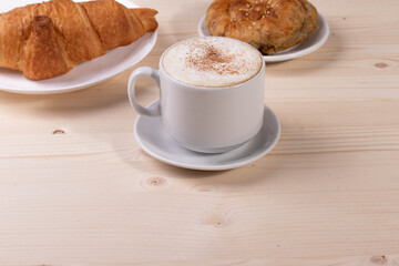 a white ceramic cup of cappucino as a coffee break concept