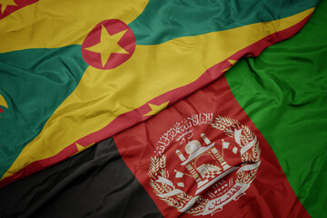 waving colorful flag of afghanistan and national flag of grenada. macro