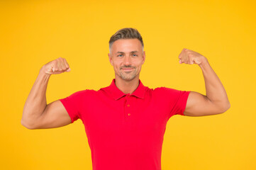 Fototapeta premium Commit to be fit. Strong man flex arms yellow background. Physical strength. Building strong biceps and triceps. Muscle workout. Power and strength. Dare to be great