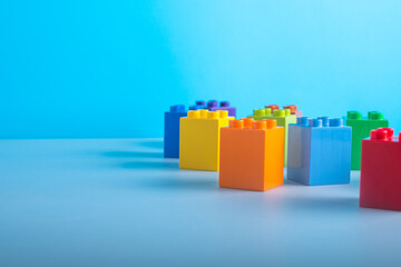 close up colored children's blocks scattering on the table.isolated on a blue background
