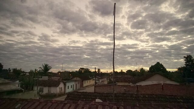 Timelapse, slow cloudscape over a village at sunset, Brazil