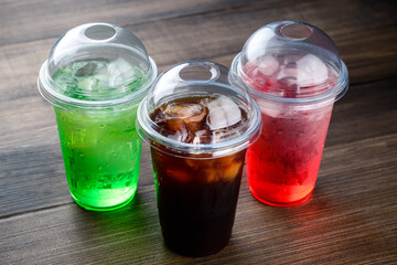 lemonade and Cola with ice in a plastic takeaway Cup