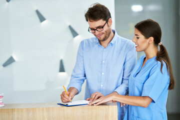 Patient signing documents in dental clinic
