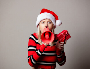 Fototapeta na wymiar Style girl in Christmas hat with megaphone and gift box