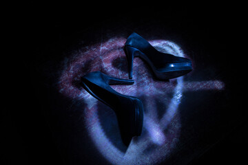 Silhouette of a high heel women shoes at dark. Women power or women domination concept.