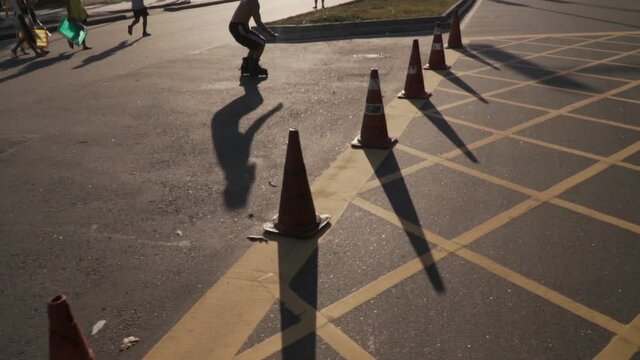 Medium, slow motion, a backlit silhouette of an inline skater jumping, Rio de Janeiro, Brazil