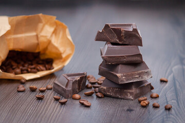 Dark chocolate with coffee beans on dark wooden background