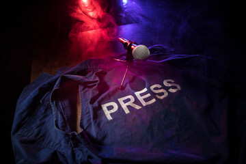 Freedom of the press and journalism concept. Blue journalist (press) vest in dark with backlight...