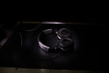 Dj music club concept. Close up headphones on dark background with colorful light.
