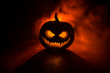 Halloween pumpkin smile and scary eyes for party night. Close up view of scary Halloween pumpkin with eyes glowing inside at black background