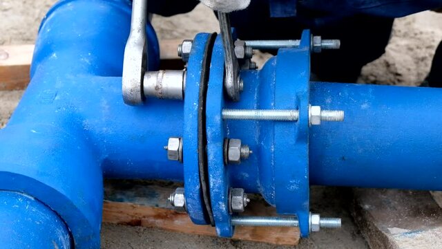 Workers installing water supply pipeline system, close up