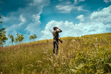 Young hunter on a hill checking his surrounding for prey