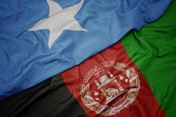 waving colorful flag of afghanistan and national flag of somalia. macro