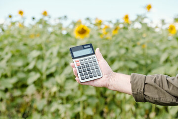 Hands of senior male farmer in workwear holding calculator with zero on display
