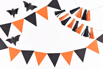Halloween background with garlands and paper bats in traditional colors orange and black on white...